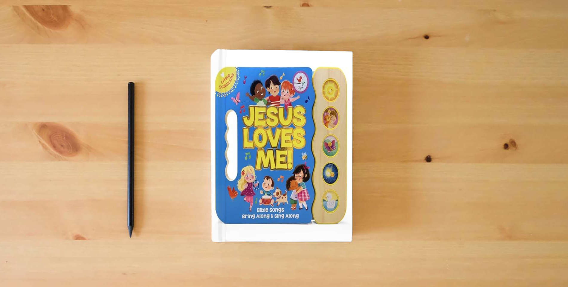 The book Jesus Loves Me 5-Button Songbook - Perfect Gift for Easter Baskets, Christmas, Birthdays, Baptisms, and More (Little Sunbeams) is on the table