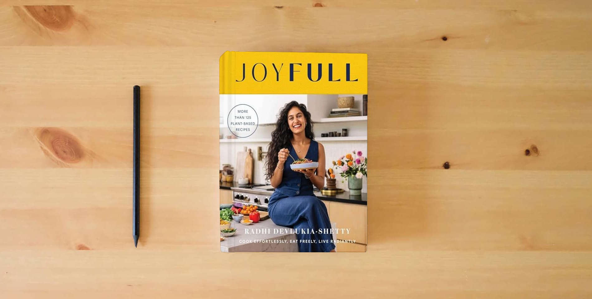 The book JoyFull: Cook Effortlessly, Eat Freely, Live Radiantly (A Cookbook) is on the table