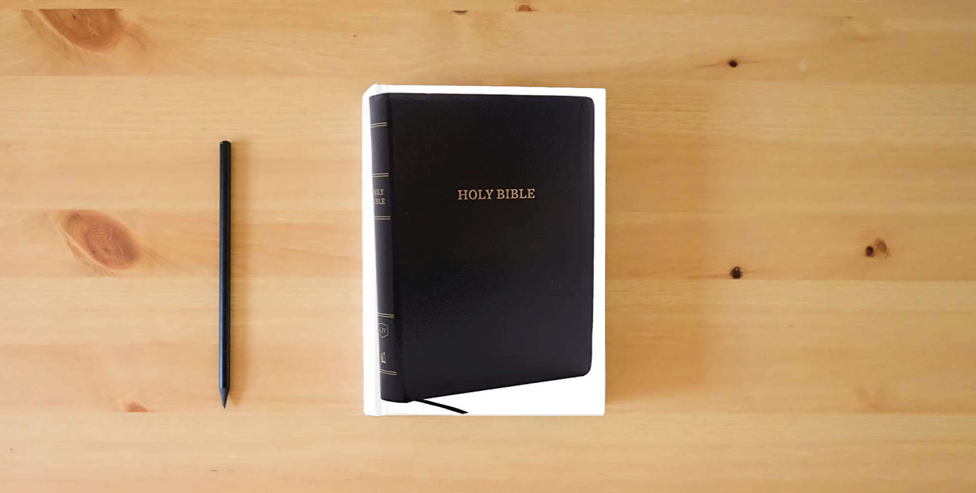The book KJV Holy Bible, Giant Print Center-Column Reference Bible, Black Leather-look, 53,000 Cross References, Red Letter, Comfort Print: King James Version is on the table