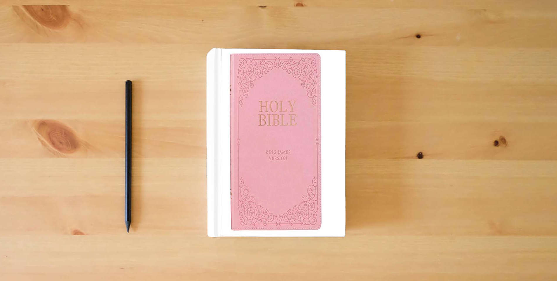 The book KJV Holy Bible, Giant Print Full-Size, Pink Faux Leather w/Ribbon Marker, Red Letter, Thumb Index, King James Version is on the table