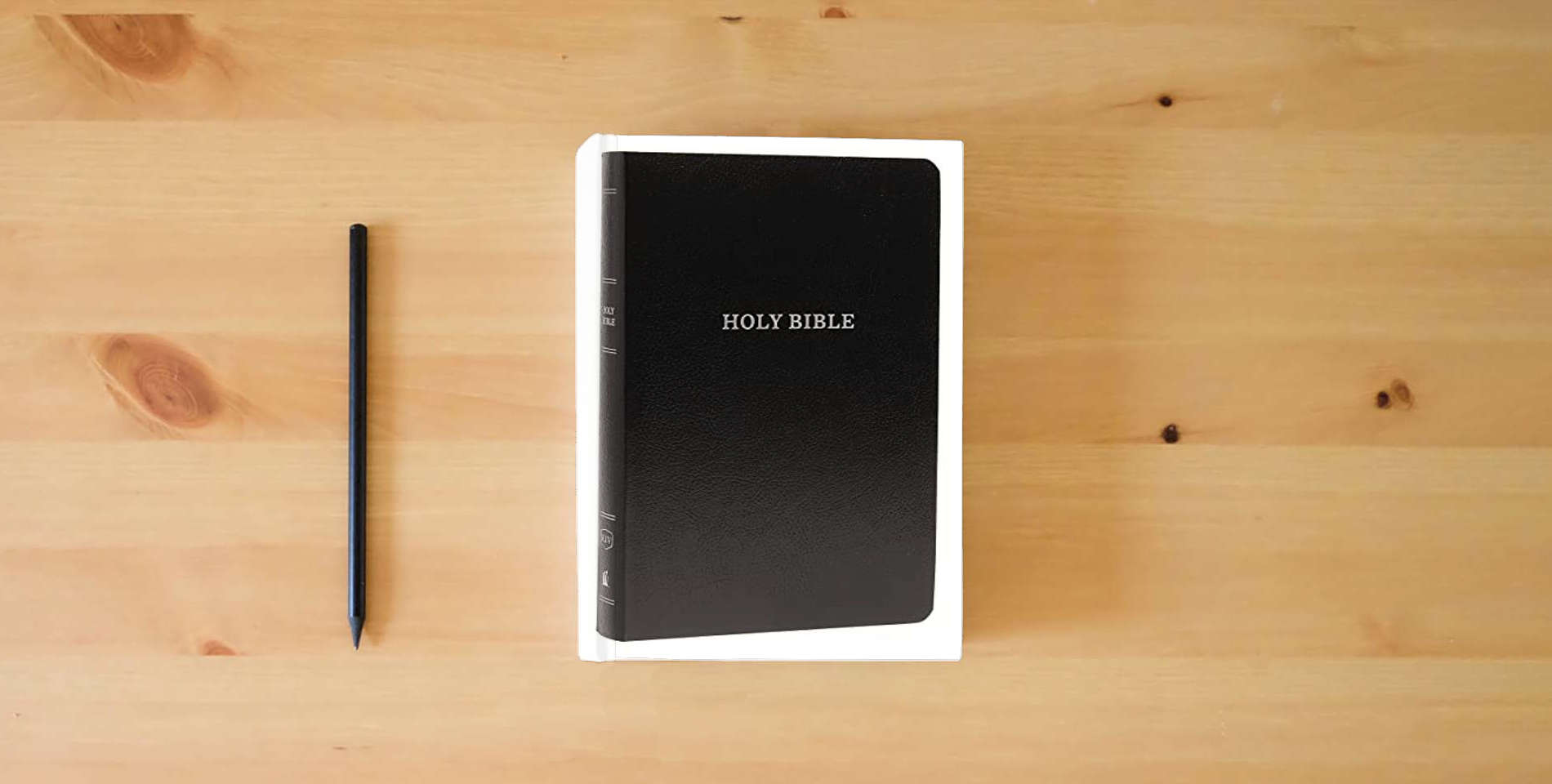 The book KJV Holy Bible: Gift and Award, Black Leather-Look, Red Letter, Comfort Print: King James Version is on the table