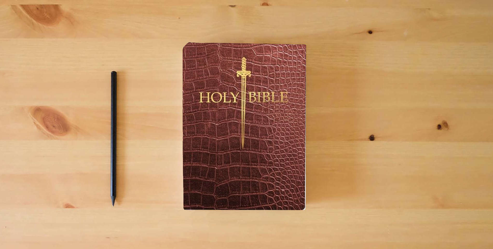 The book KJV Sword Bible, Large Print, Walnut Alligator Bonded Leather, Thumb Index: (Red Letter, Burgundy, 1611 Version) (King James Version Sword Bible) is on the table