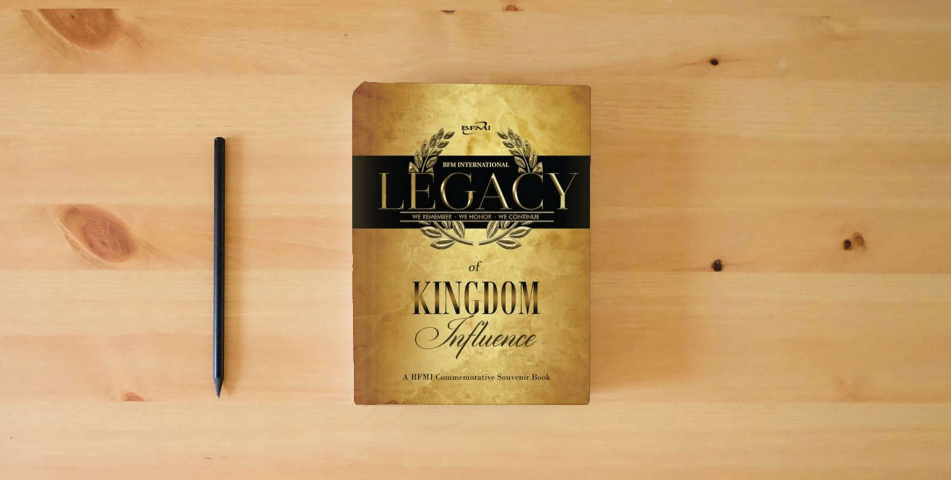 The book Legacy of Kingdom Influence: A BFMI Commemorative Souvenir Book is on the table