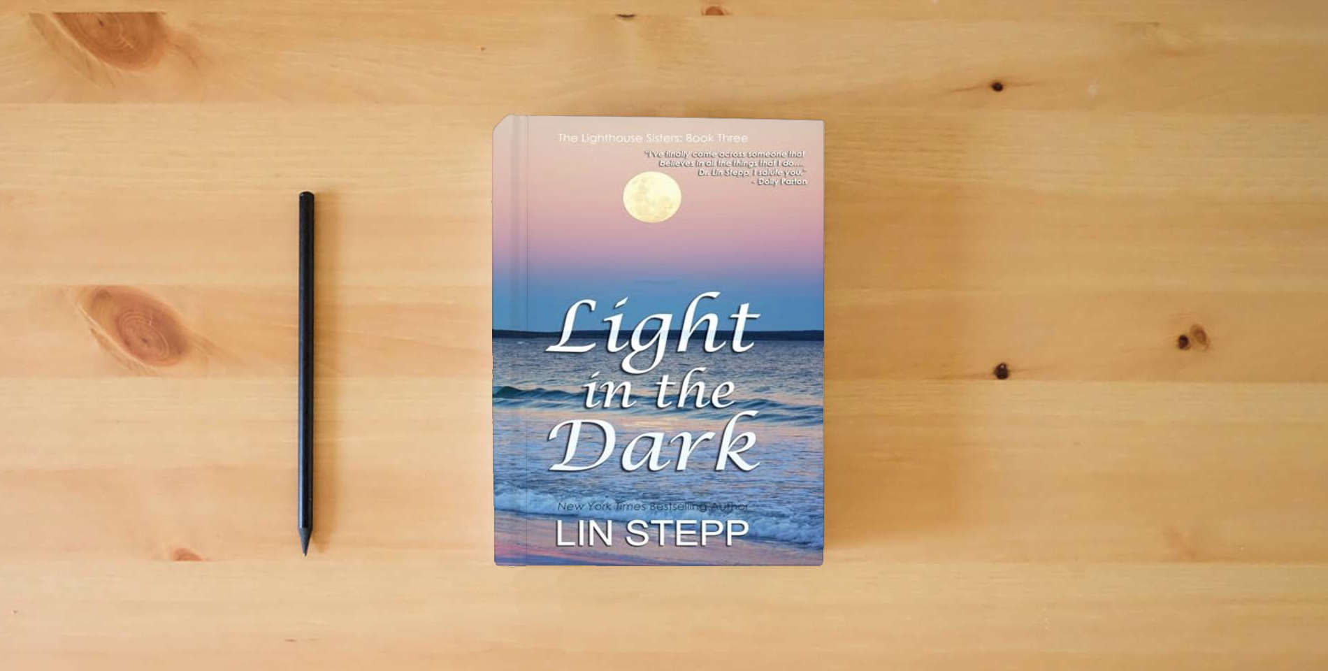 The book Light In The Dark is on the table