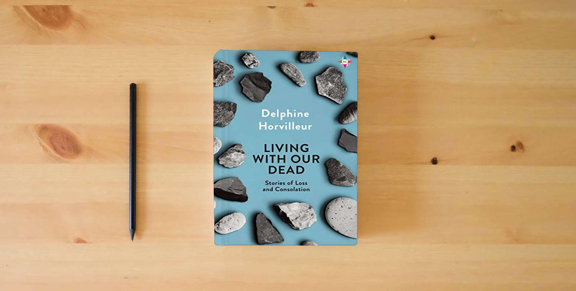 The book Living with Our Dead: Stories of Loss and Consolation is on the table