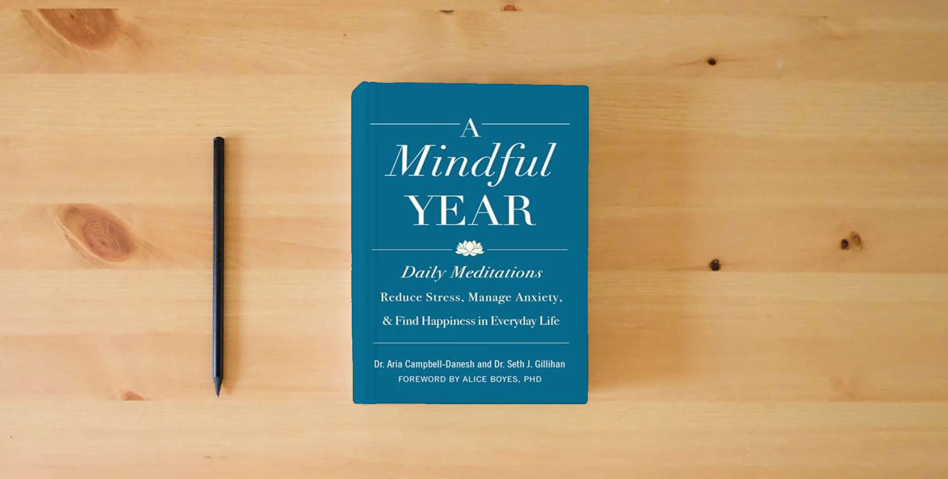 The book A Mindful Year: Daily Meditations: Reduce Stress, Manage Anxiety, and Find Happiness in Everyday Life is on the table