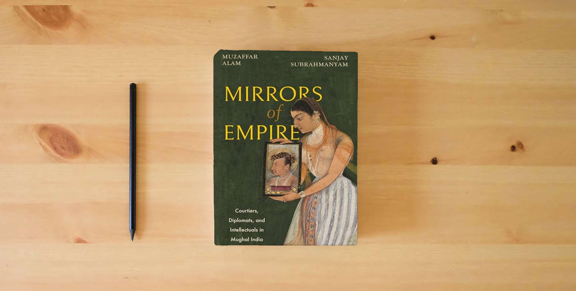 The book Mirrors of Empire: Courtiers, Diplomats, and Intellectuals in Mughal India is on the table