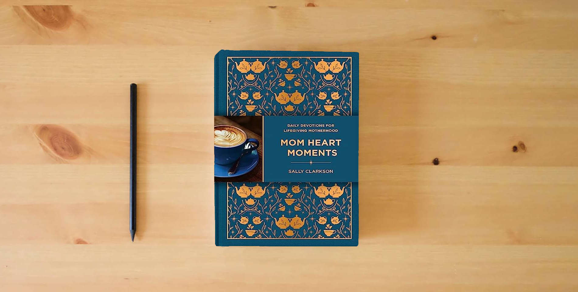 The book Mom Heart Moments: Daily Devotions for Lifegiving Motherhood is on the table