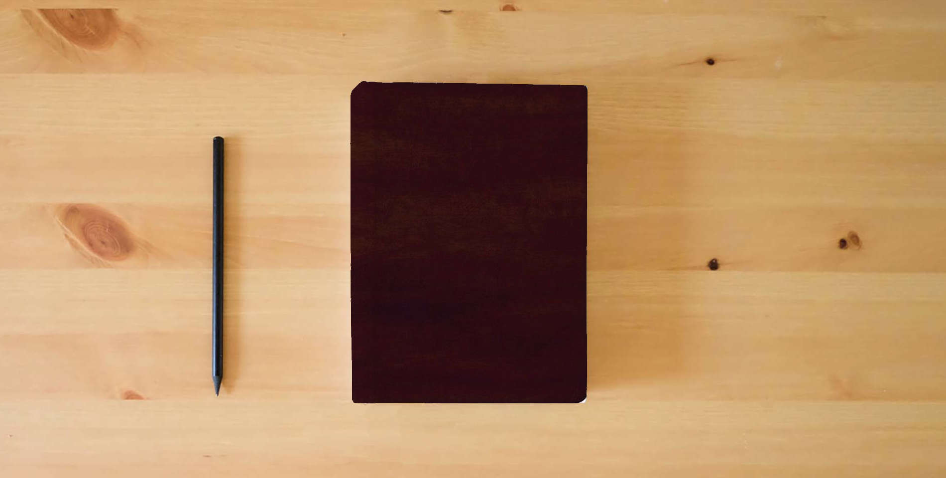 The book GW Names of God Bible Mahogany, Hebrew Name Design Duravella is on the table