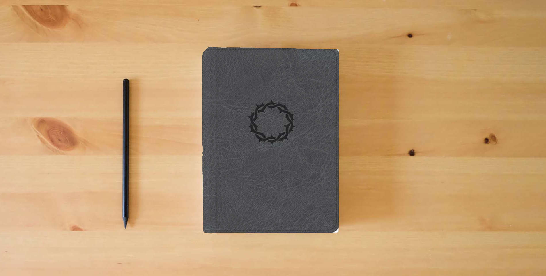 The book NASB Large Print Compact Reference Bible, Charcoal LeatherTouch, Red Letter, Presentation Page, Sewn Binding, Cross-References, Full-Color Maps, Easy-to-Read Bible Karmina Type is on the table