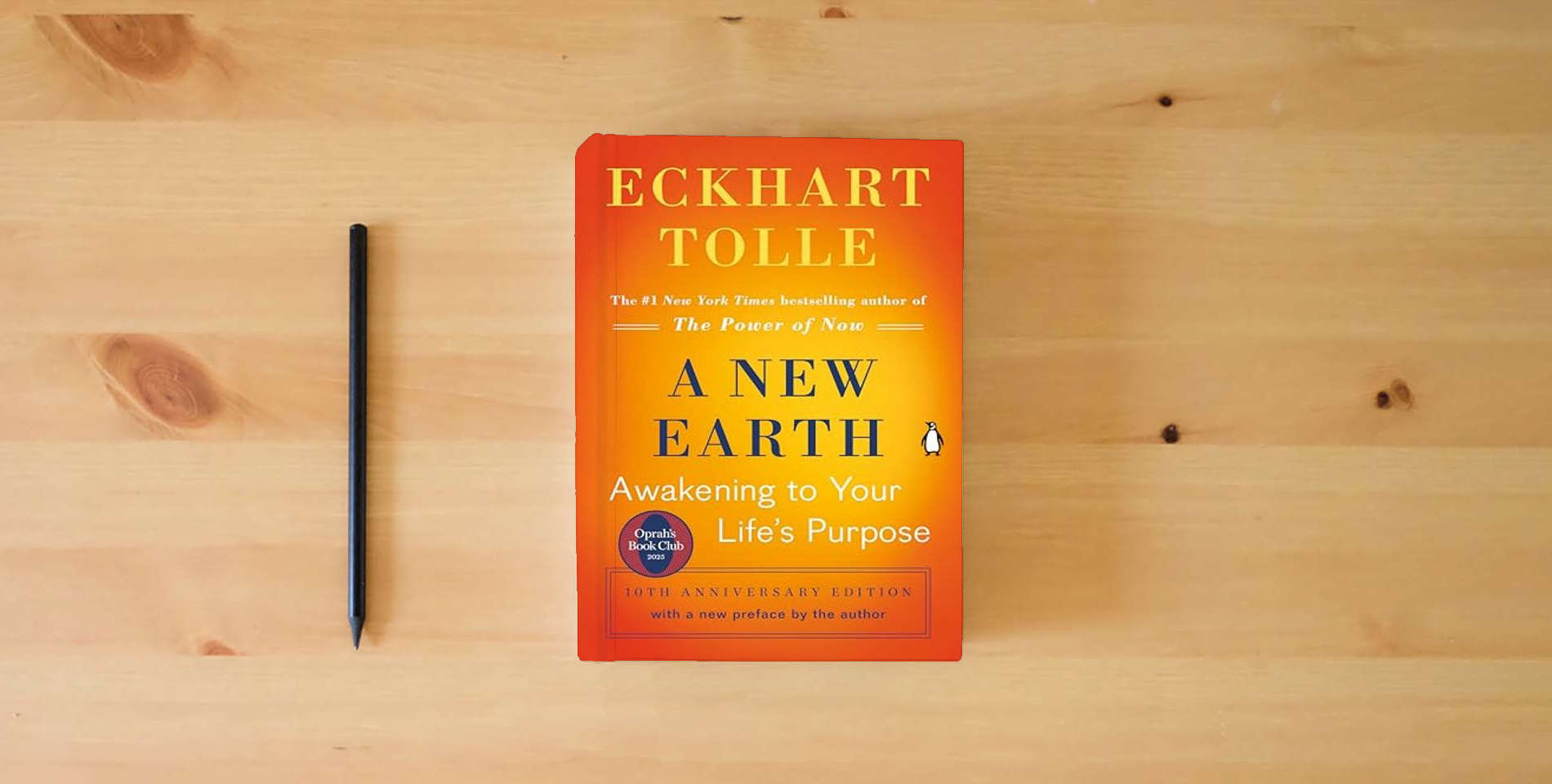 The book A New Earth: Awakening to Your Life's Purpose (Oprah's Book Club, Selection 61) is on the table