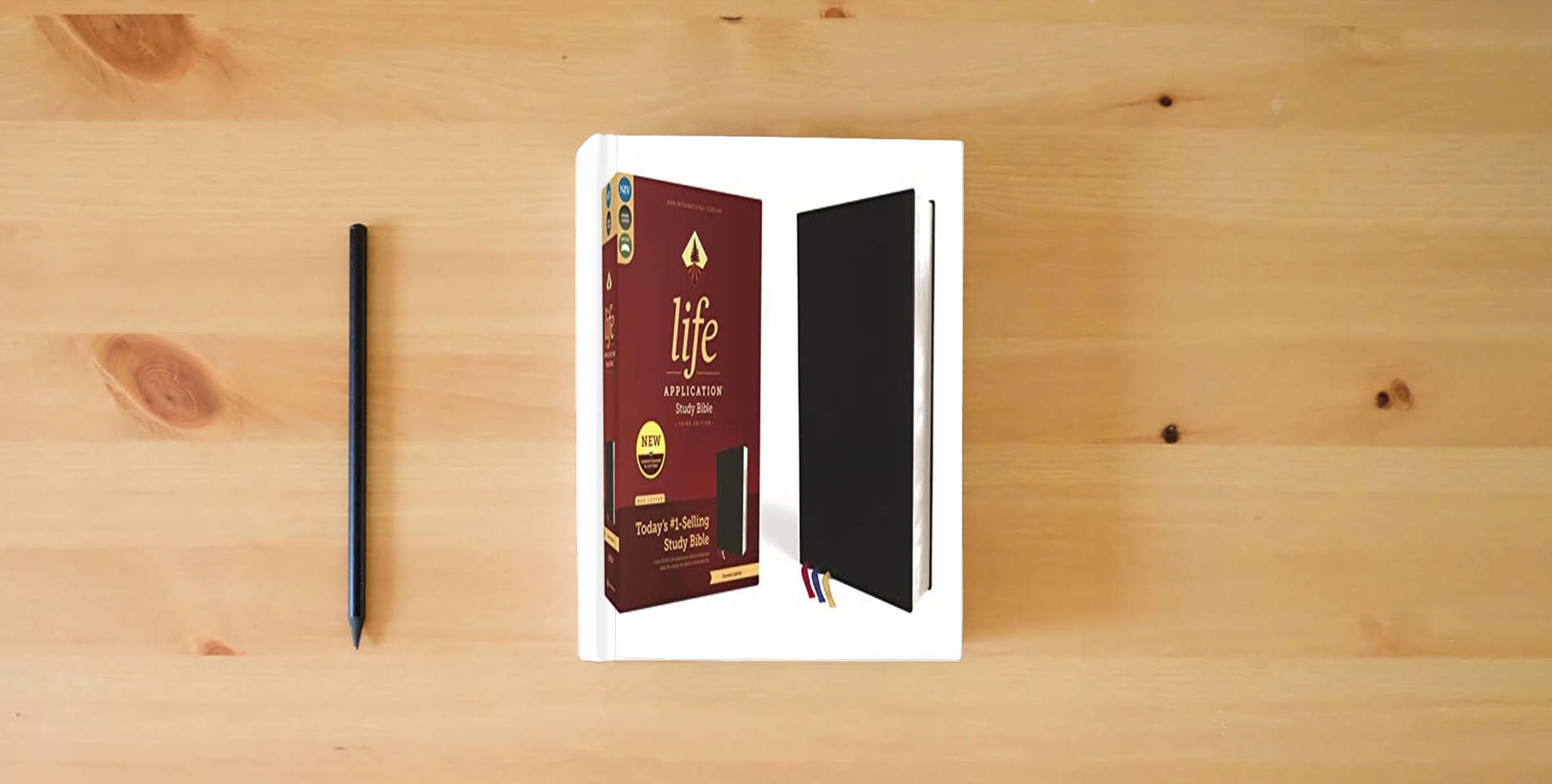 The book NIV, Life Application Study Bible, Third Edition, Genuine Leather, Cowhide, Black, Art Gilded Edges, Red Letter is on the table