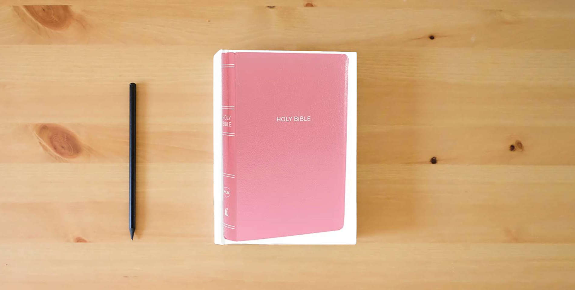 The book NKJV, Gift and Award Bible, Leather-Look, Pink, Red Letter, Comfort Print: Holy Bible, New King James Version is on the table