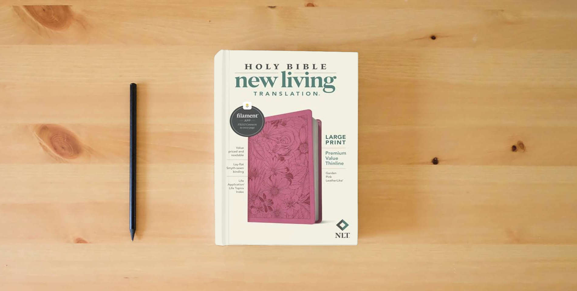 The book NLT Large Print Premium Value Thinline Bible, Filament Enabled (LeatherLike, Garden Pink) is on the table