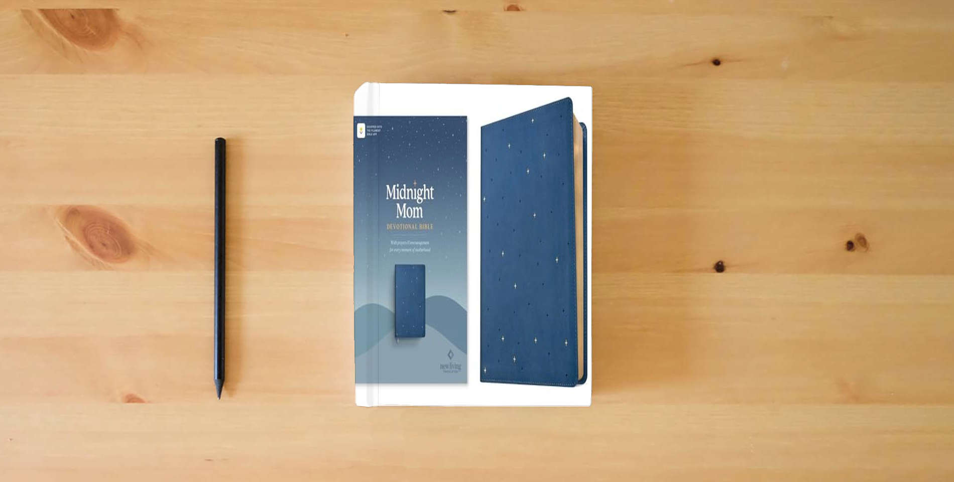 The book NLT Midnight Mom Devotional Bible (LeatherLike, Starlit Navy, Red Letter, Filament Enabled): With Prayers and Encouragement for Every Moment of Motherhood is on the table