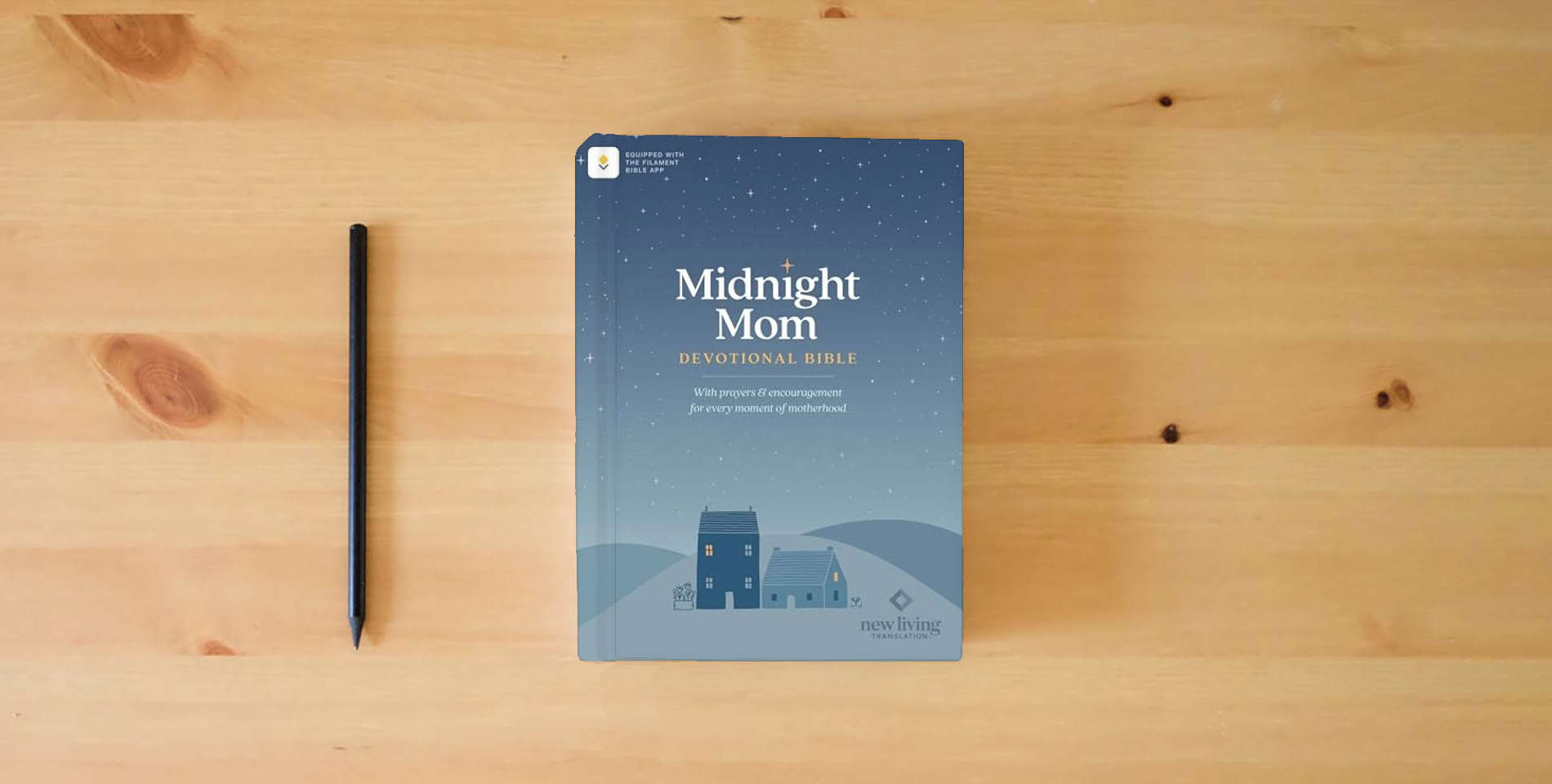 The book NLT Midnight Mom Devotional Bible (Softcover, Red Letter, Filament Enabled): With Prayers and Encouragement for Every Moment of Motherhood is on the table