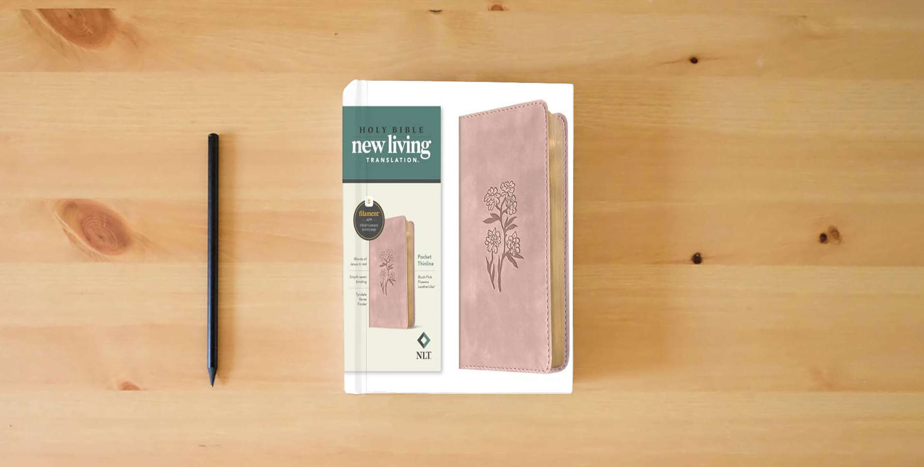 The book NLT Pocket Thinline Bible, Filament Enabled (LeatherLike, Blush Pink Flowers, Red Letter) is on the table