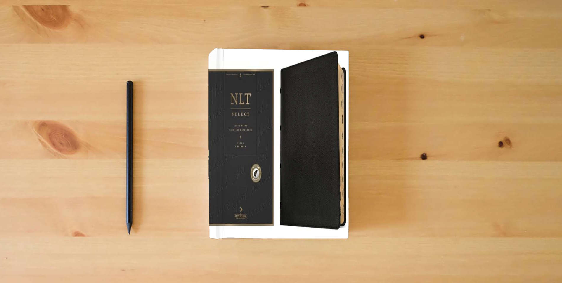 The book NLT Select Large Print Thinline Reference Bible, Filament Enabled (Goatskin Leather, Black, Indexed, Red Letter) is on the table