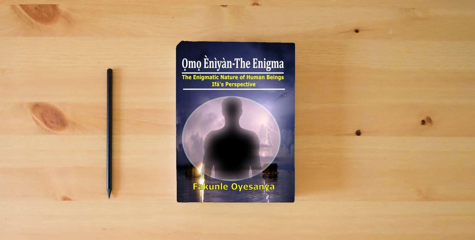 The book Omo Eniyan-The Enigma: The Enigmatic Nature of Human Beings (Ifa' Perspective) is on the table