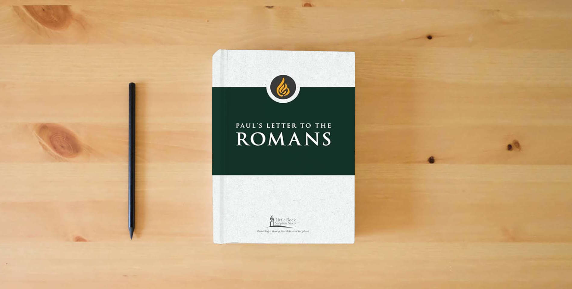 The book Paul's Letter to the Romans (Little Rock Scripture Study) is on the table