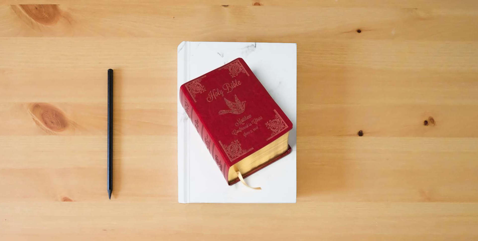 The book Personalized Catholic Bible for Confirmation & RCIA – Custom Name Engraved Cover, Catholic Confirmation Keepsake for Teens & Adults - New American Bible Revised Edition (NAB-RE) is on the table