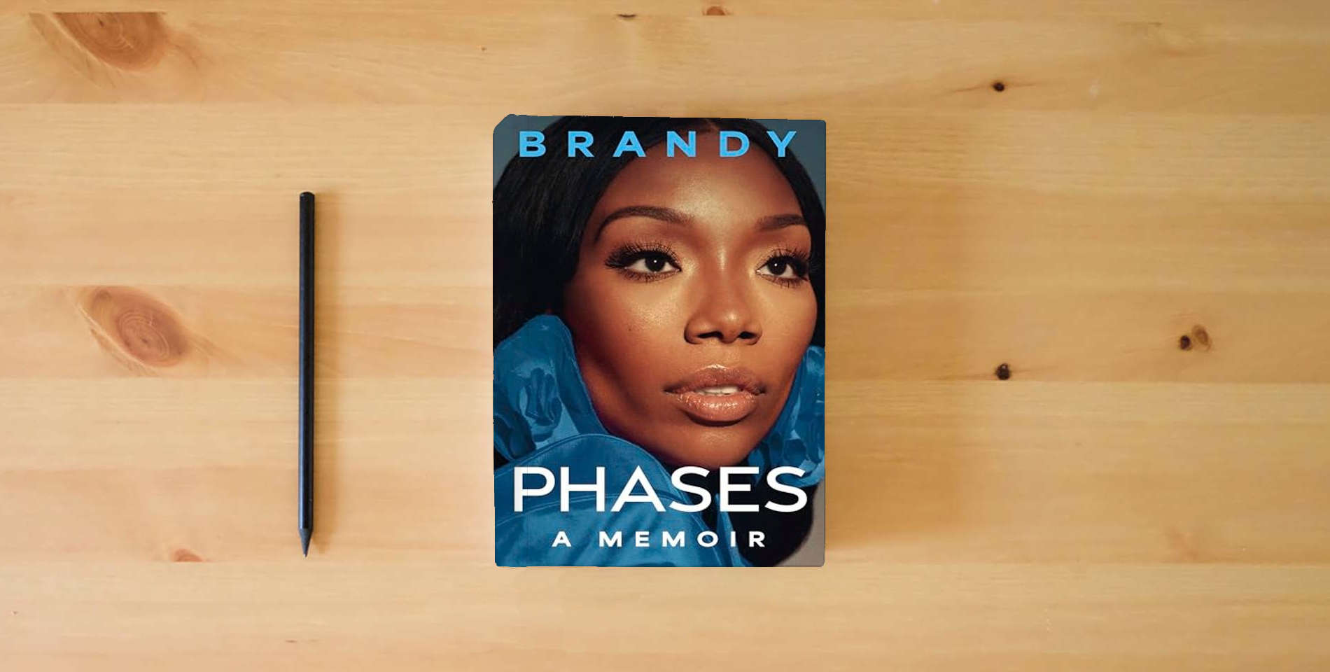 The book Phases: A Memoir – An Intimate Biography of the Multiplatinum Music Legend and Star of Moesha and Cinderella is on the table