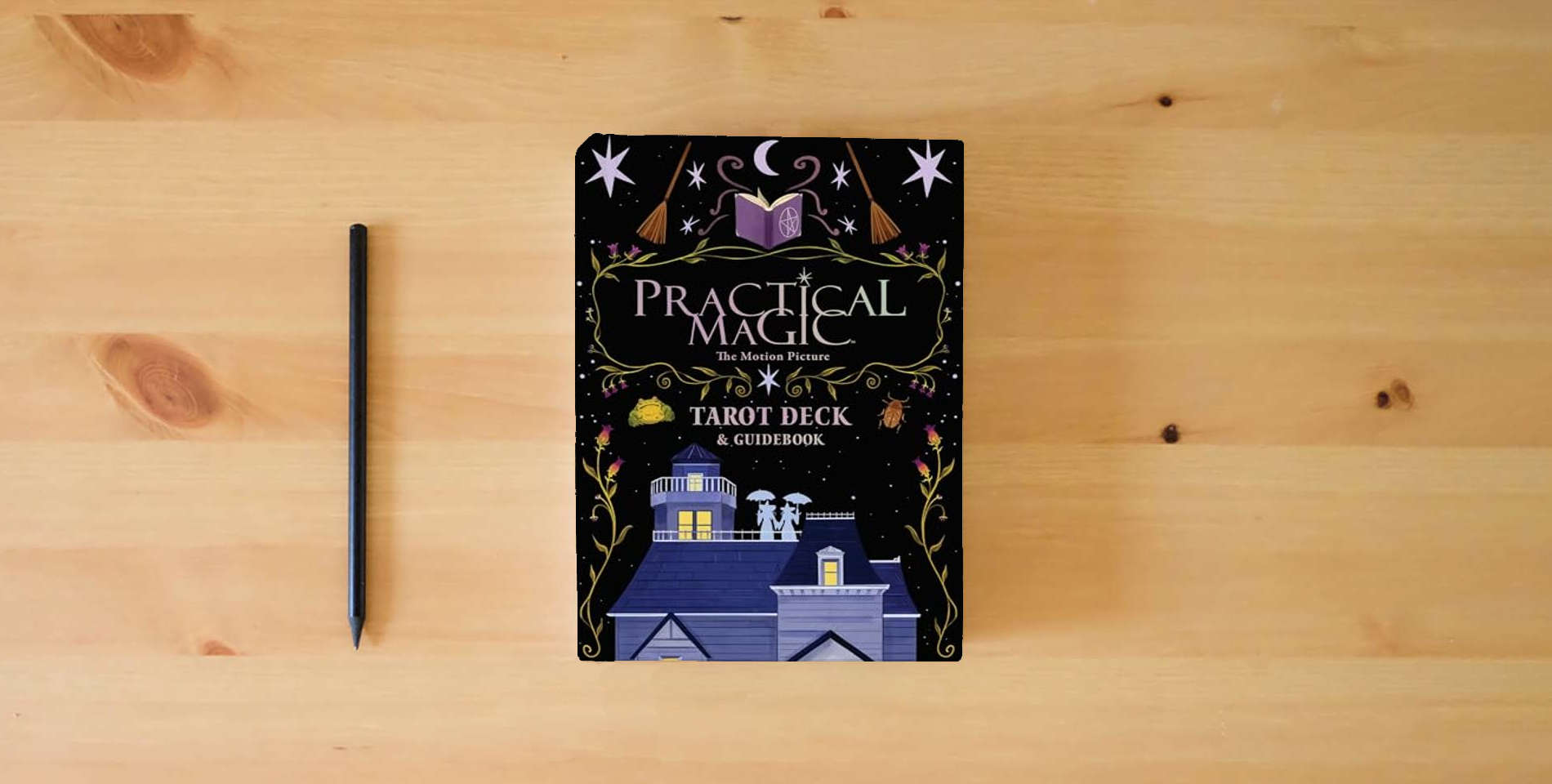 The book Practical Magic: The Motion Picture: The Official Tarot Deck and Guidebook is on the table