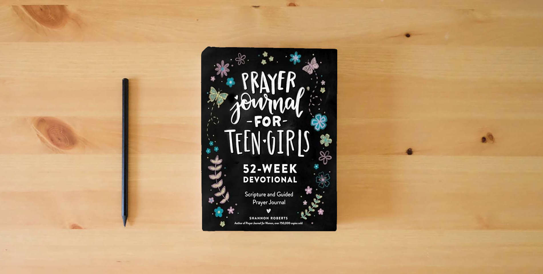 The book Prayer Journal for Teen Girls: 52-week Scripture, Devotional, & Guided Prayer Journal is on the table