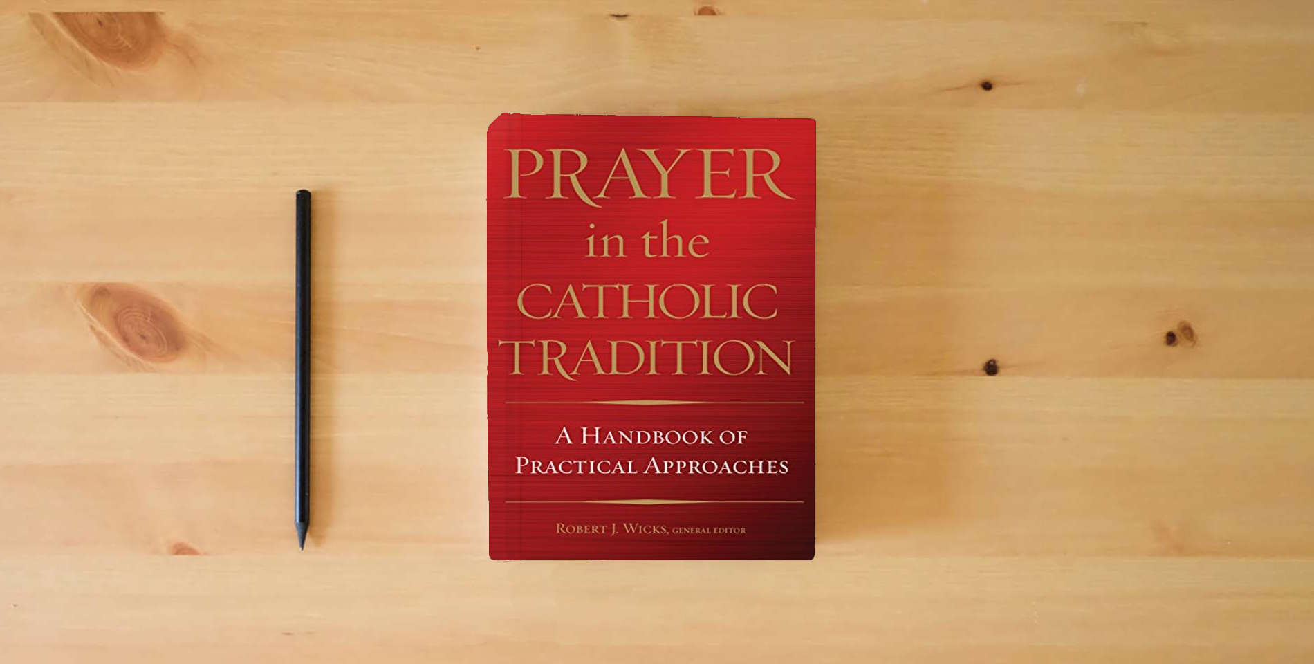 The book Prayer in the Catholic Tradition: A Handbook of Practical Approaches is on the table
