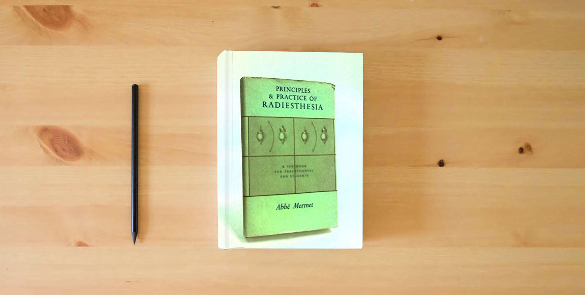 The book Principles and Practice of Radiesthesia: Textbook for Practitioners and Students is on the table
