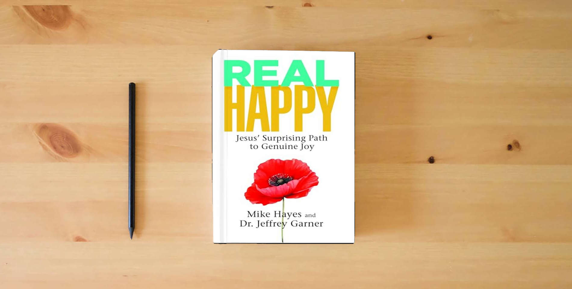 The book Real Happy: Jesus’ Surprising Path to Genuine Joy is on the table
