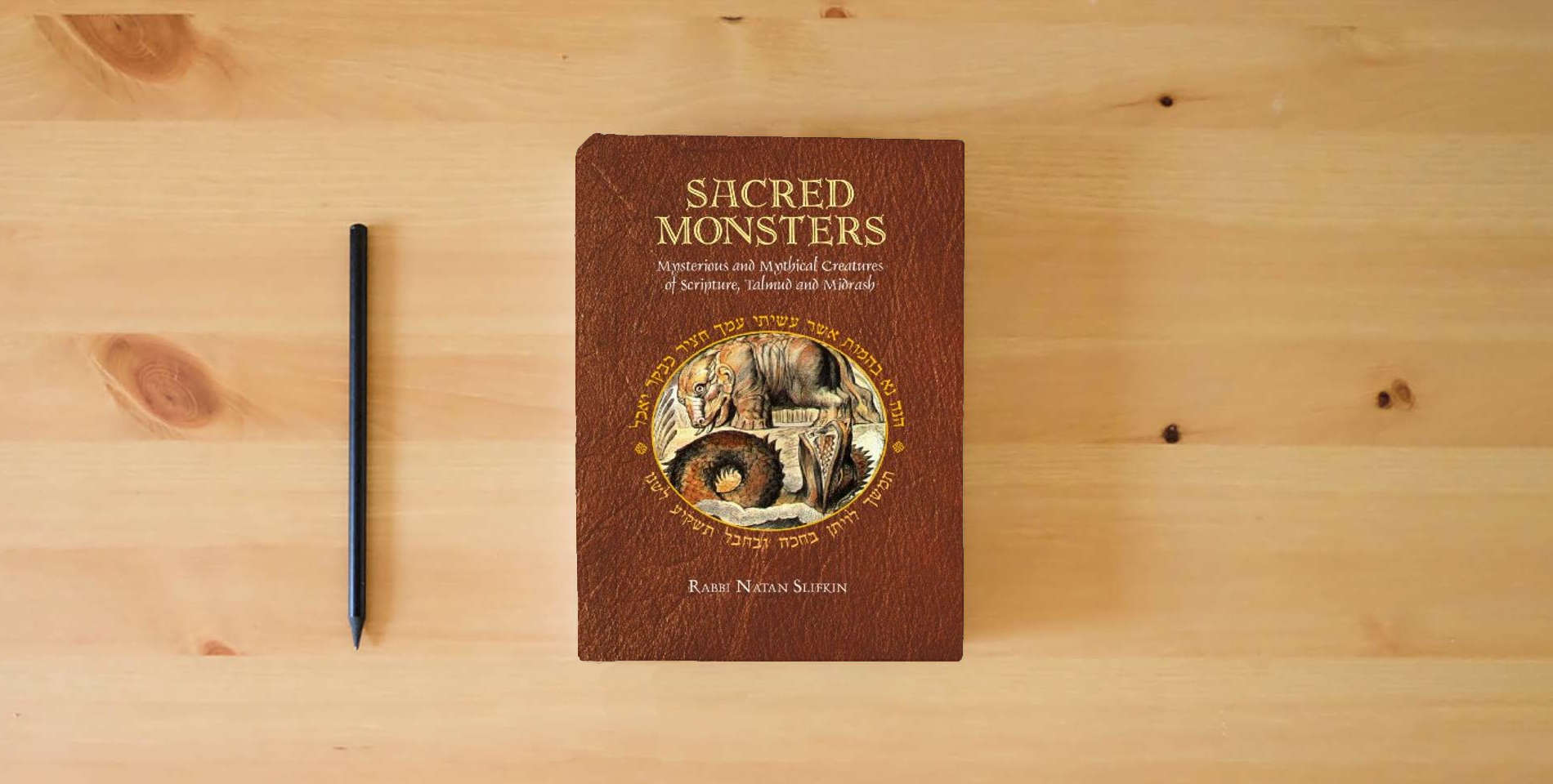 The book Sacred Monsters: Mysterious and Mythical Creatures of Scripture, Talmud and Midrash is on the table