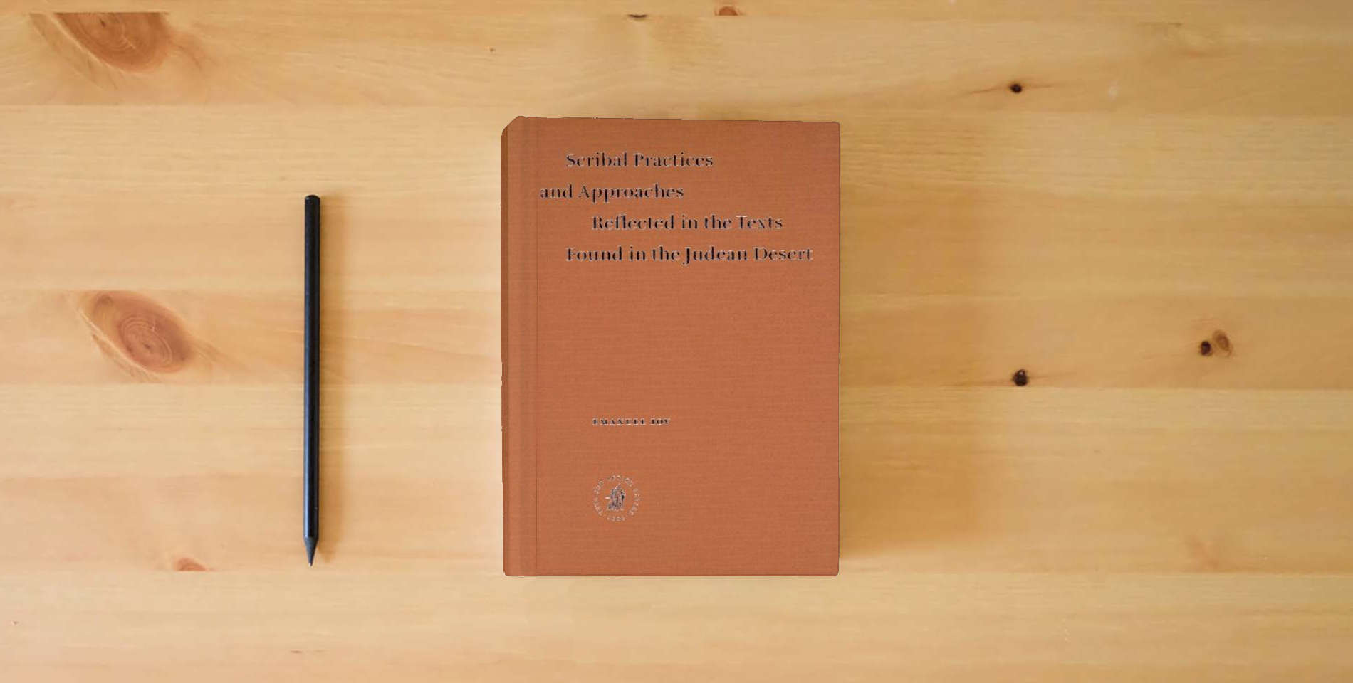The book Scribal Practices And Approaches Reflected In The Texts Found In The Judean Desert (Studies on the Texts of the Desert of Judah) is on the table