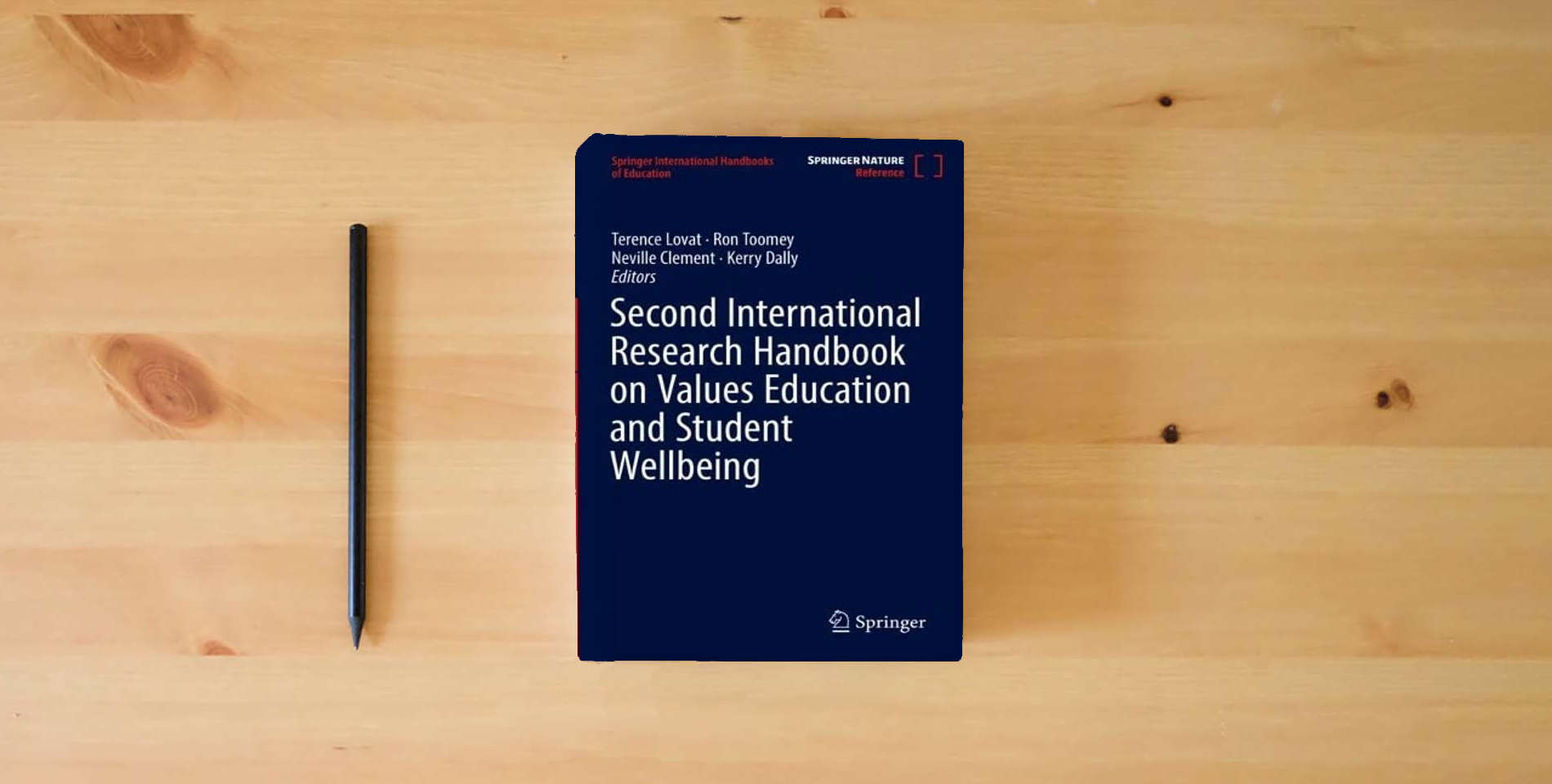 The book Second International Research Handbook on Values Education and Student Wellbeing (Springer International Handbooks of Education) is on the table
