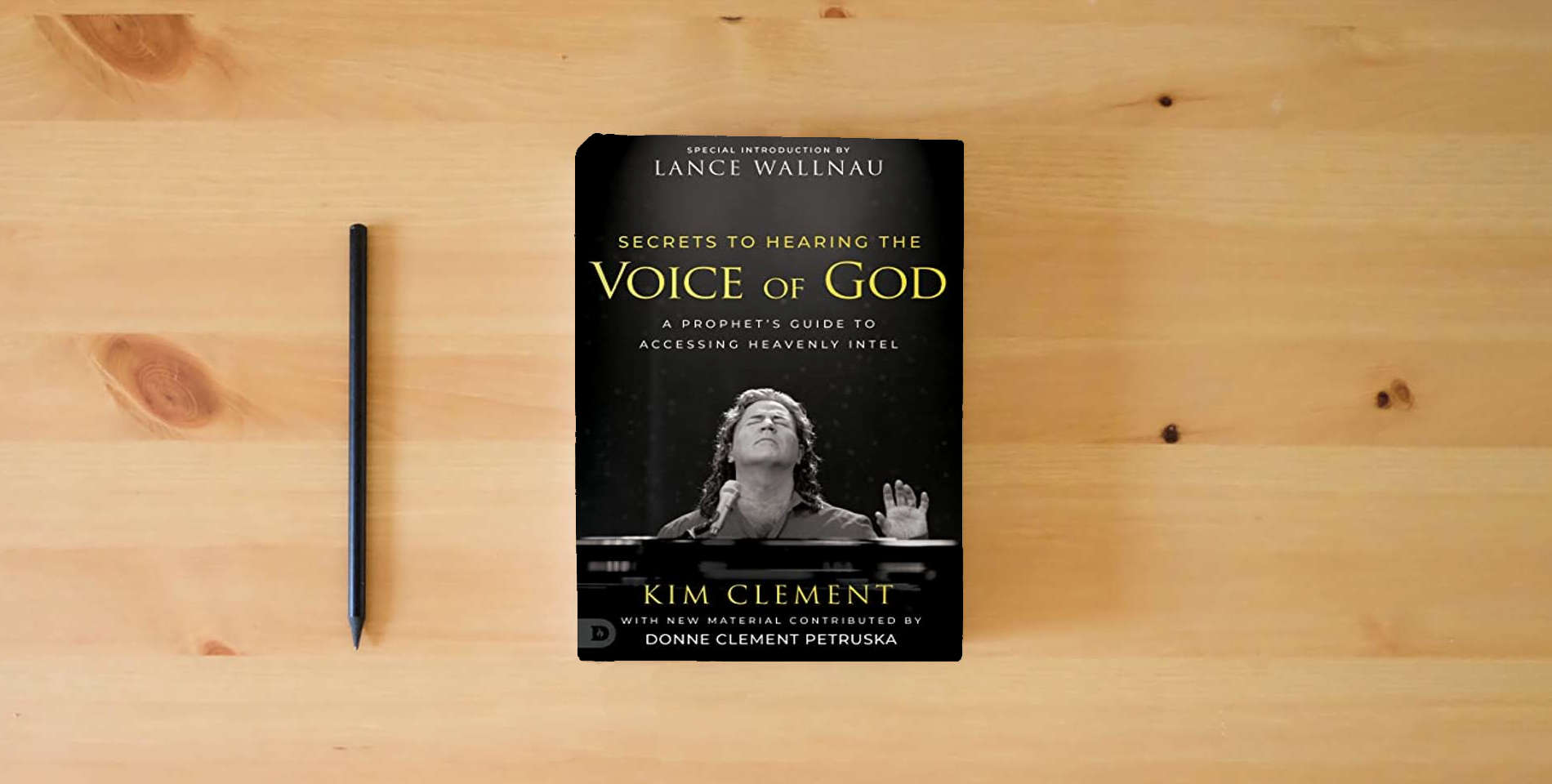 The book Secrets to Hearing the Voice of God: A Prophet's Guide to Accessing Heavenly Intel is on the table