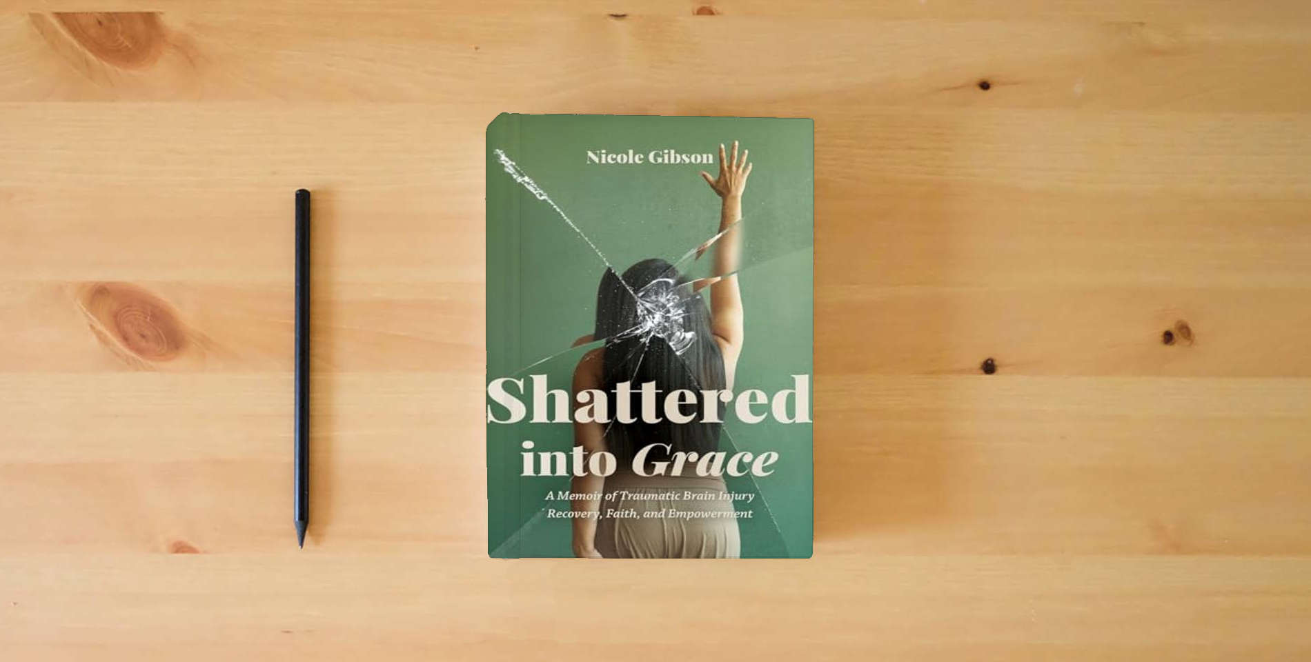The book Shattered into Grace: A Memoir of Traumatic Brain Injury Recovery, Faith, and Empowerment is on the table