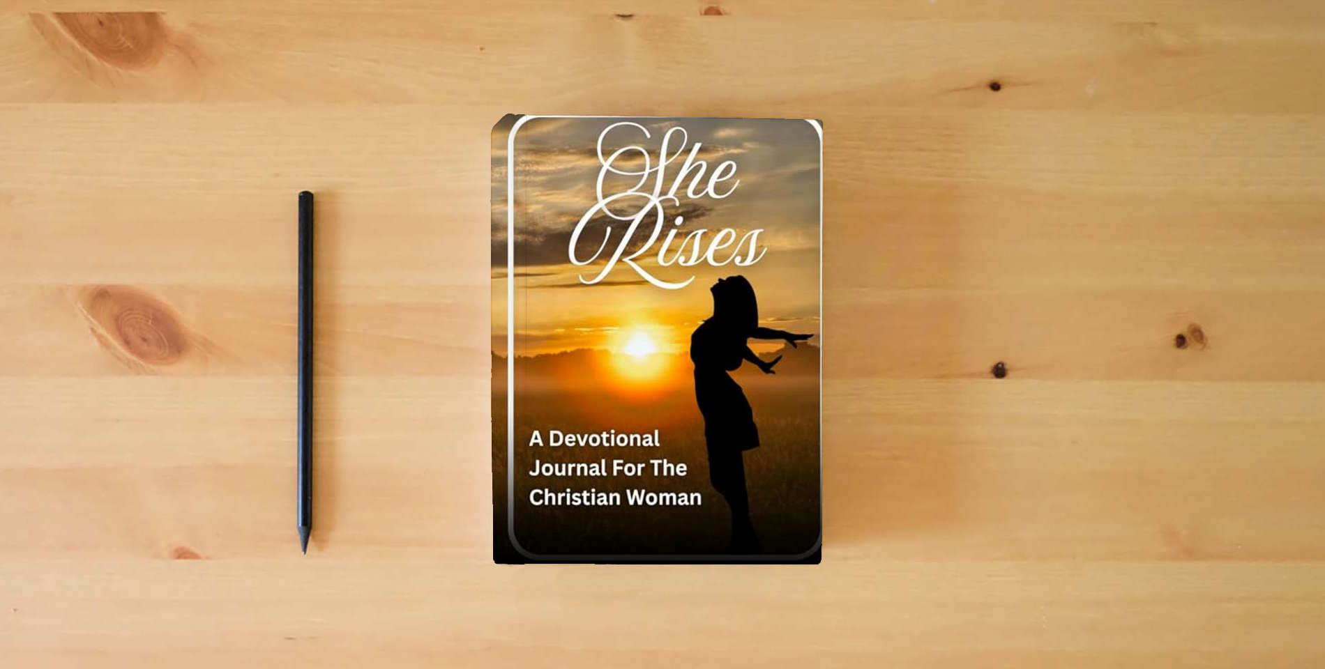 The book She Rises: A Devotional Journal For The Christian Woman is on the table