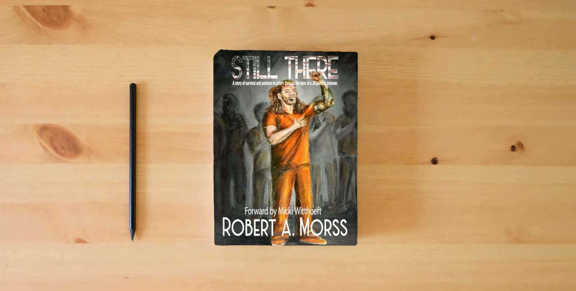 The book STILL THERE: A story of survival and penance in prison through the eyes of a J6 Political Prisoner is on the table