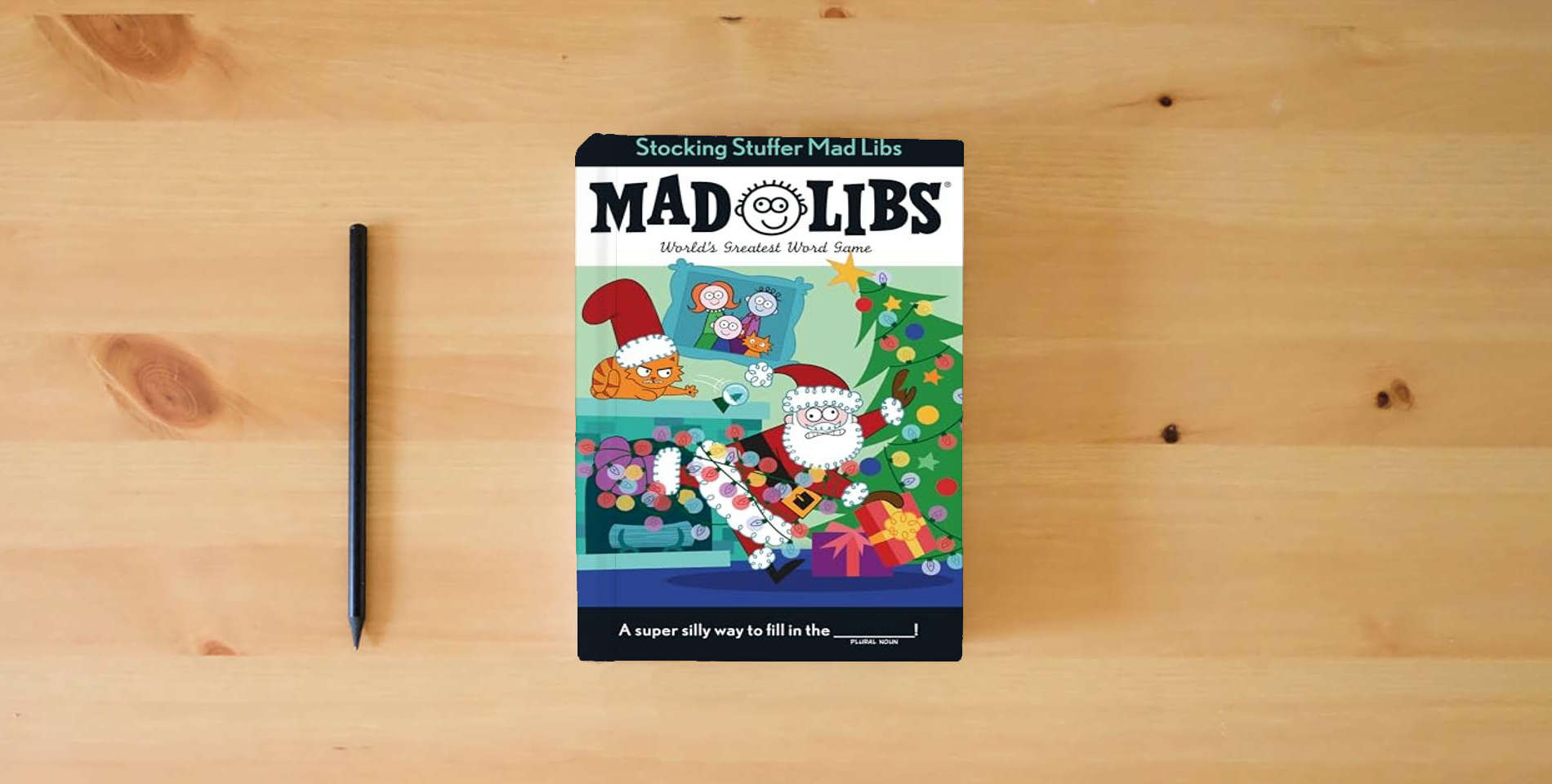 The book Stocking Stuffer Mad Libs: World's Greatest Word Game About Christmas is on the table
