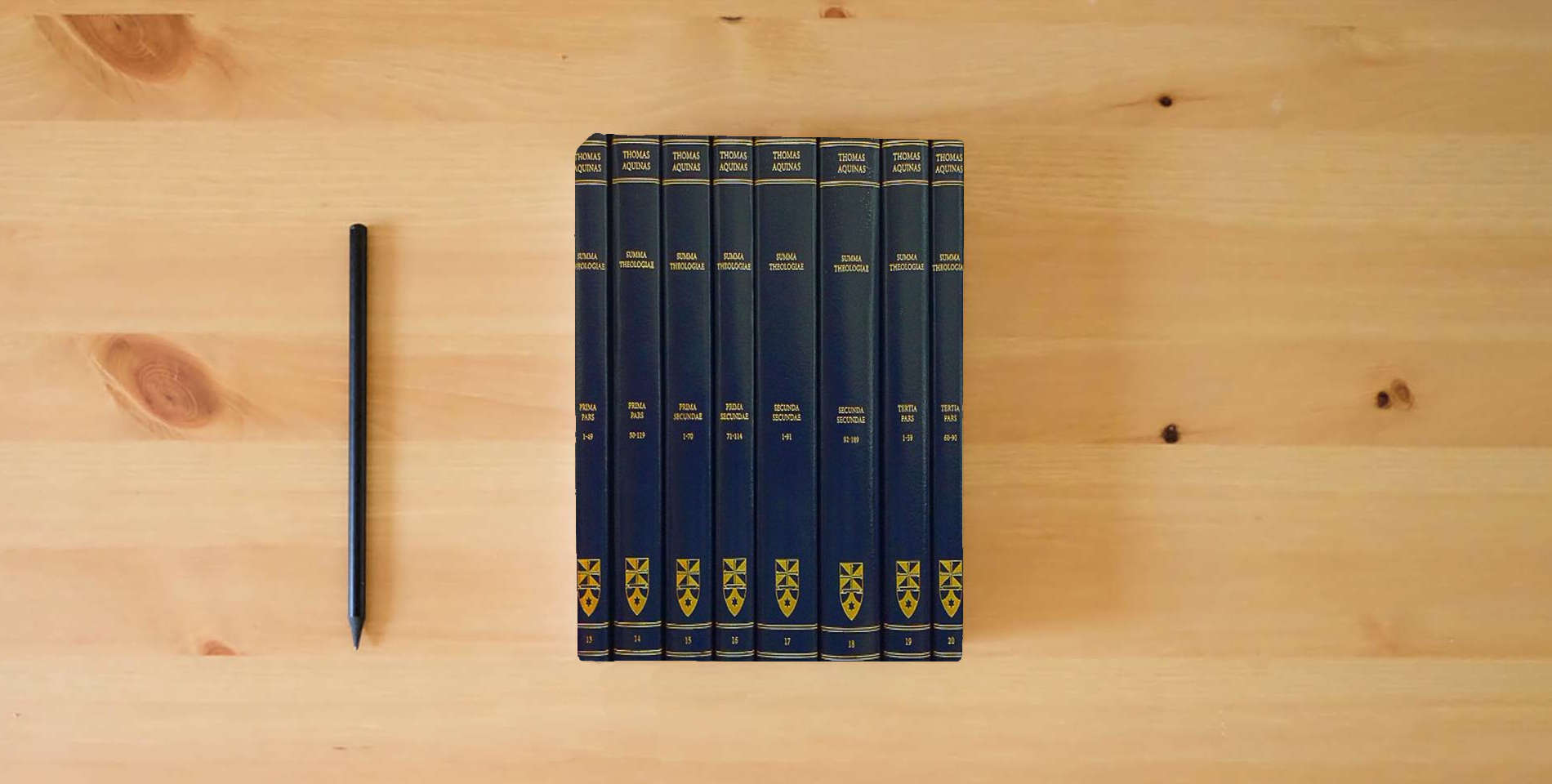 The book Summa Theologiae: Complete Set is on the table