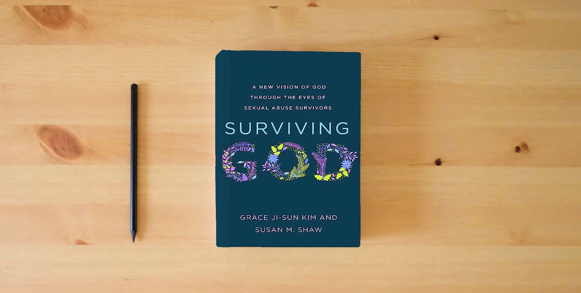 The book Surviving God: A New Vision of God through the Eyes of Sexual Abuse Survivors is on the table