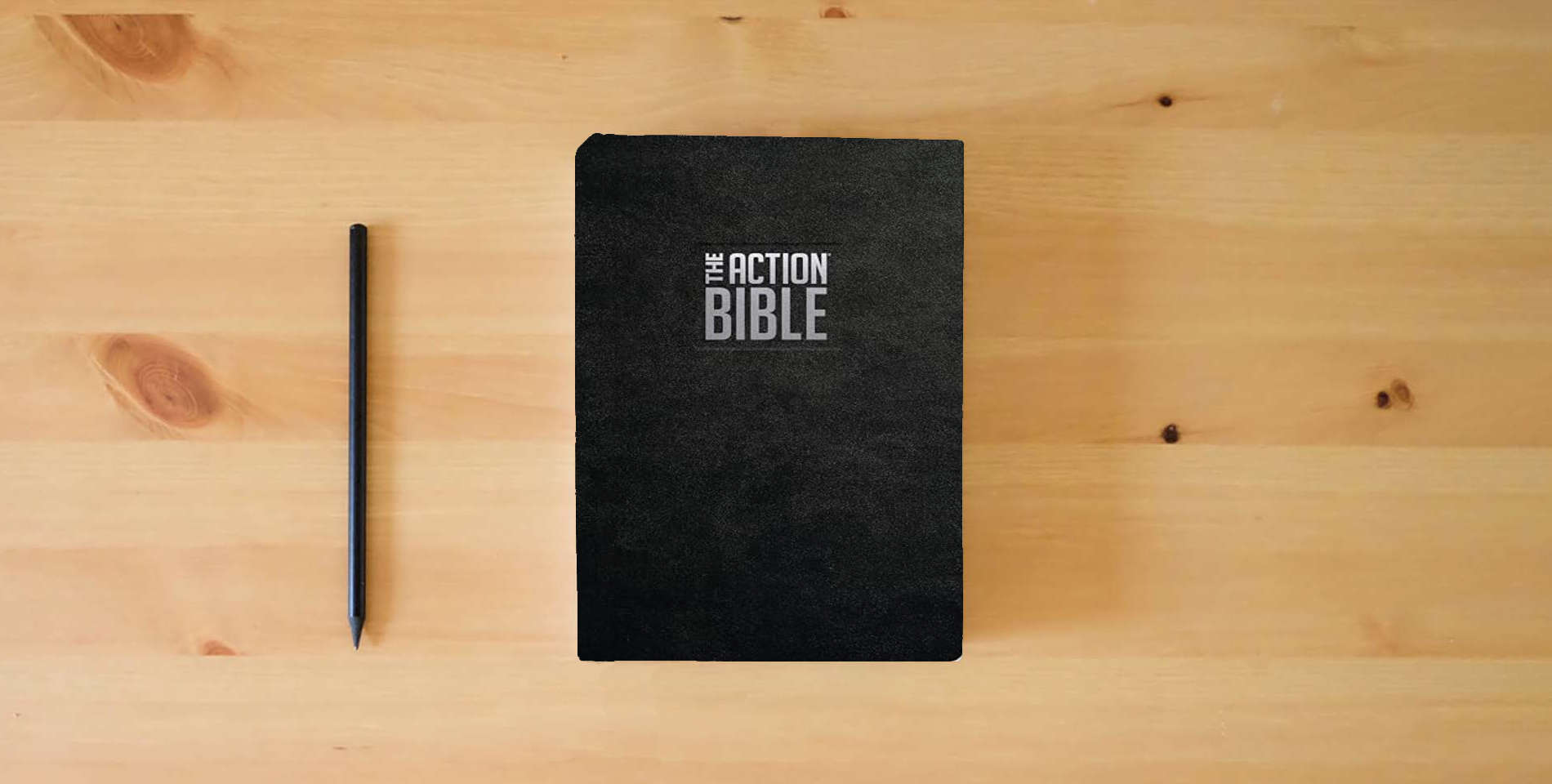 The book The Action Bible Premium Edition, Leathersoft, Full Color (Action Bible Series) is on the table