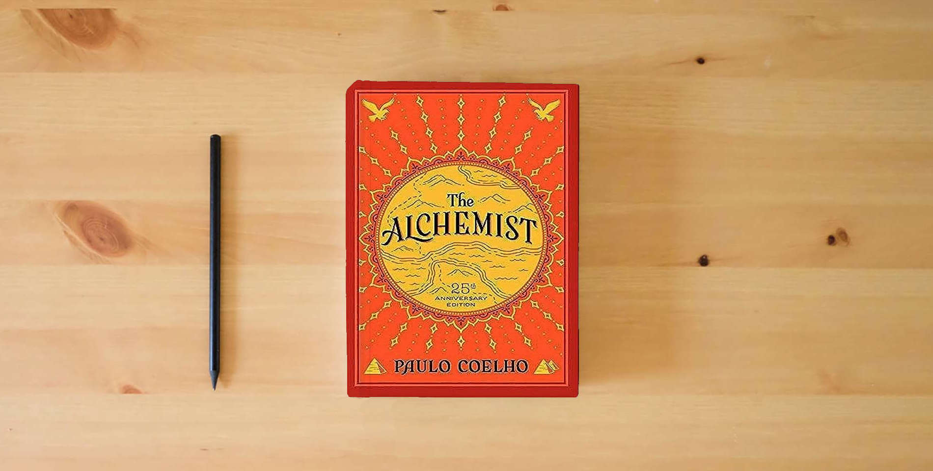 The book The Alchemist, 25th Anniversary: A Fable About Following Your Dream is on the table