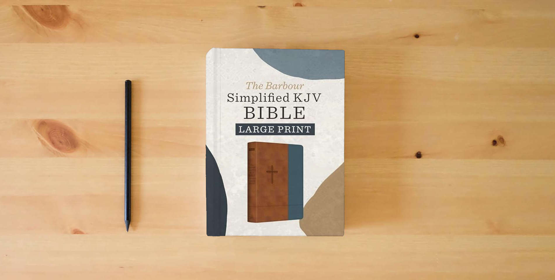 The book The Barbour Simplified Kjv--Large Print [Rust & Stone Cross] is on the table
