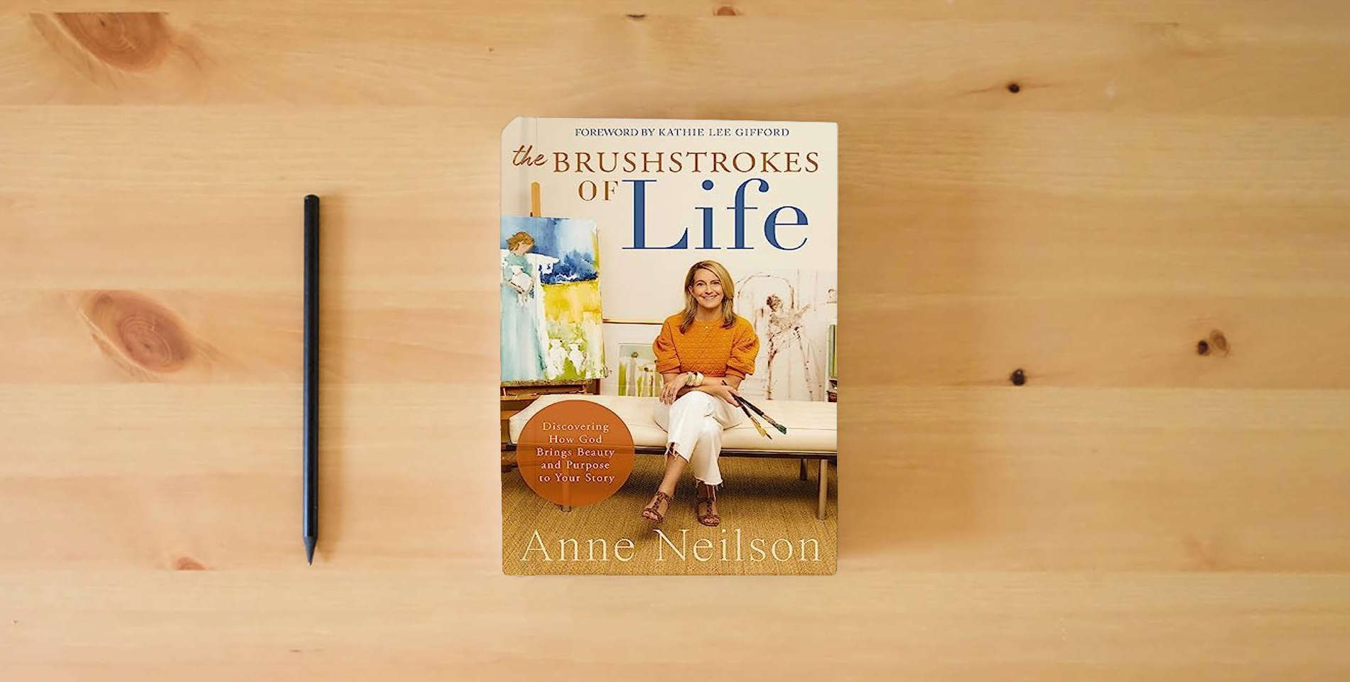 The book The Brushstrokes of Life: Discovering How God Brings Beauty and Purpose to Your Story is on the table