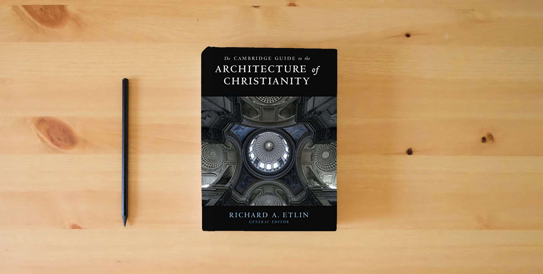 The book The Cambridge Guide to the Architecture of Christianity 2 Volume Hardback Set is on the table