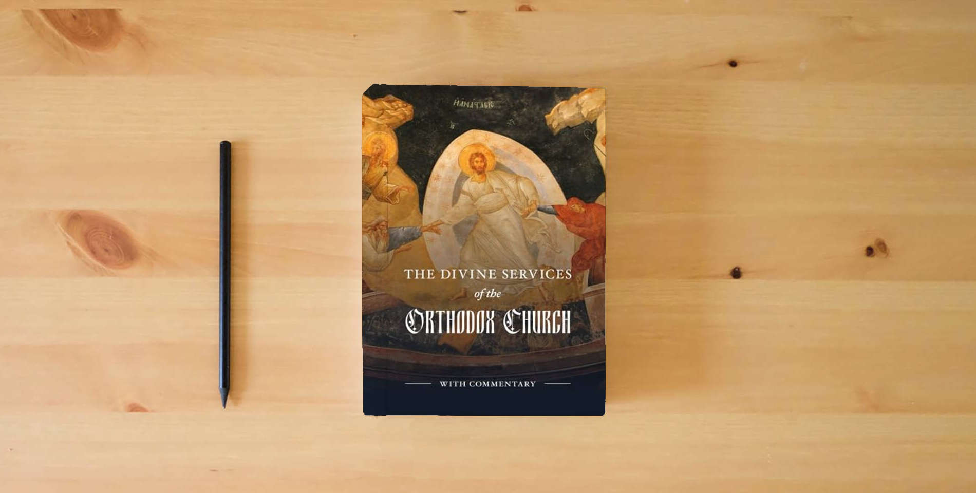 The book The Divine Services of the Orthodox Church: With Commentary-Full Color is on the table