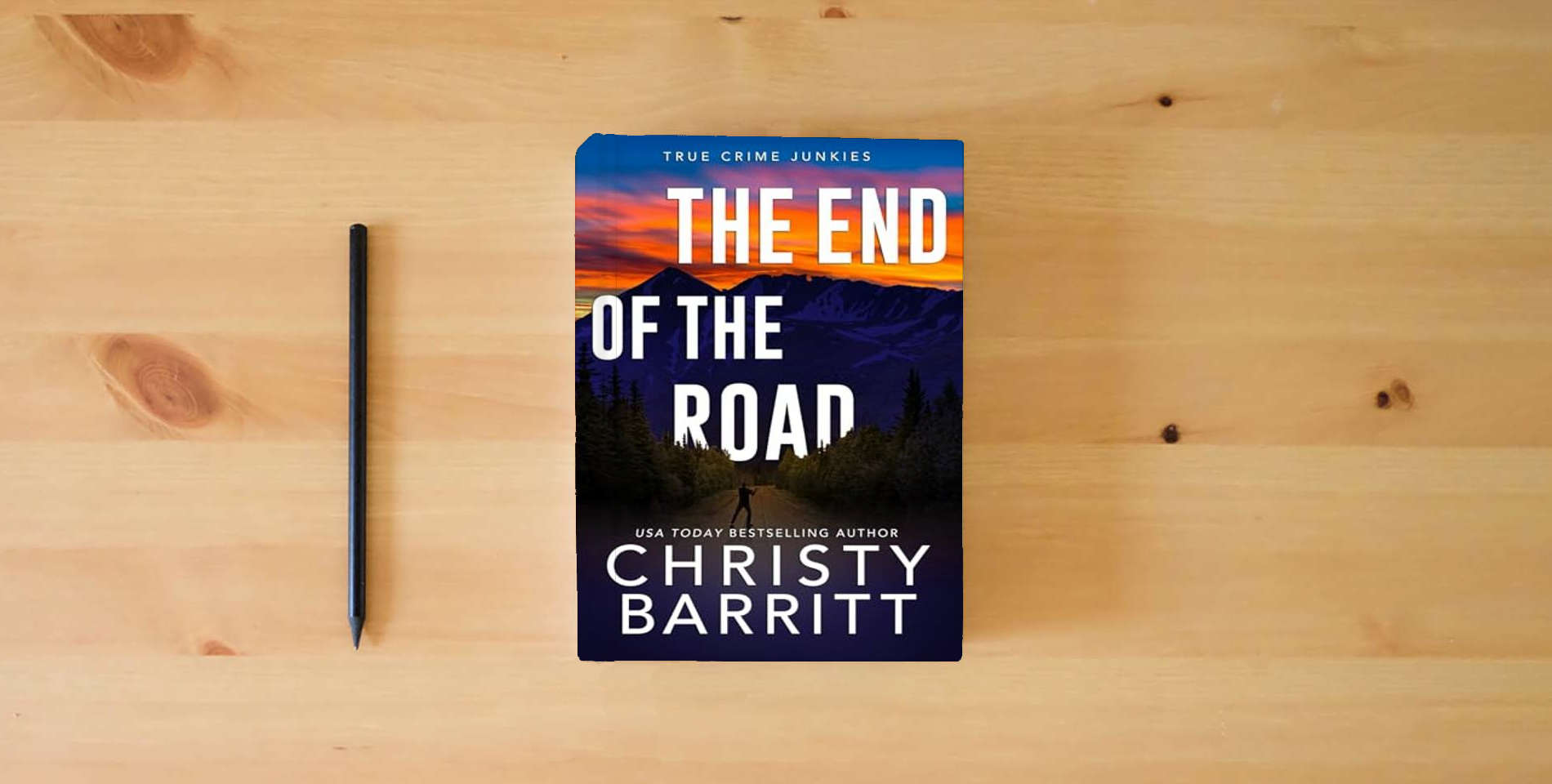 The book The End of the Road (True Crime Junkies) is on the table