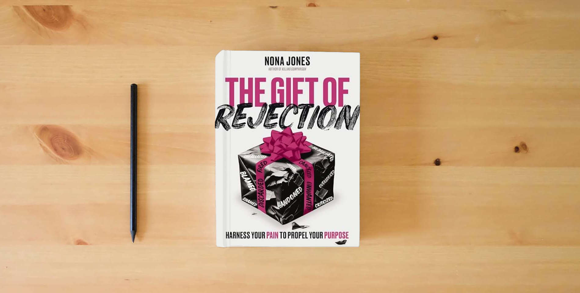 The book The Gift of Rejection: Harness Your Pain to Propel Your Purpose is on the table