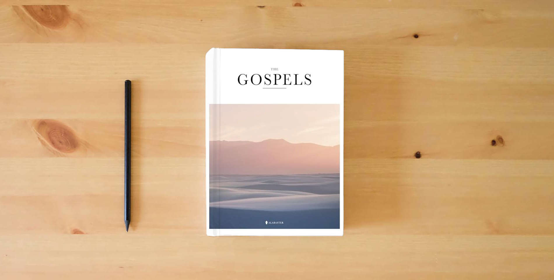 The book The Gospels (HC,NLT) is on the table